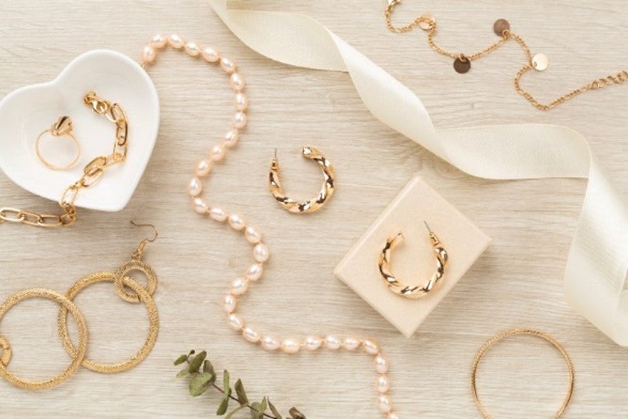 Elegant golden jewelry with decoration on a wooden background in Houston, TX